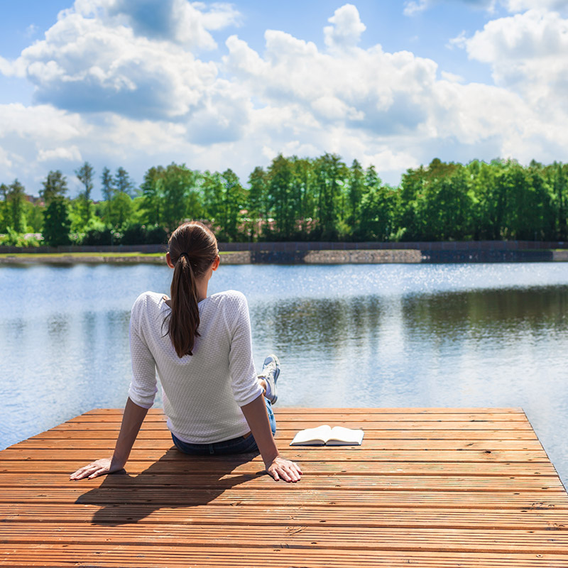 Woman relaxing by a beautiful lake.